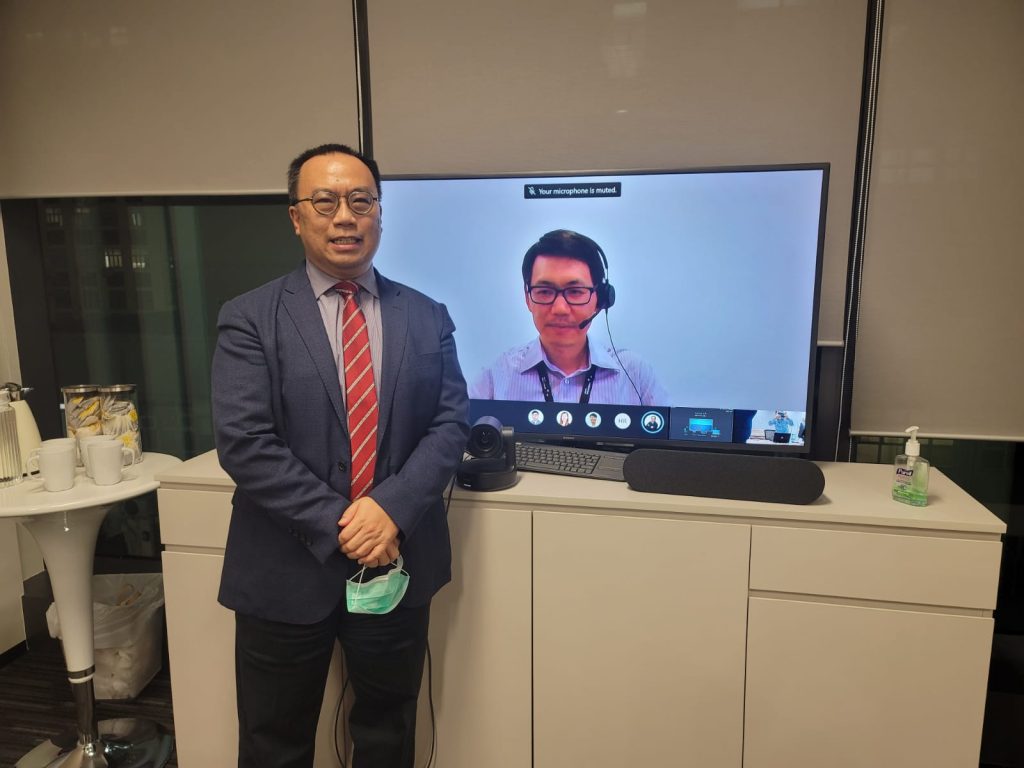 Man stands near screen with another man