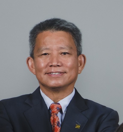 Headshot of a smiling man in suit and patterned tie