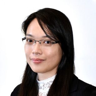 Professional headshot of a woman with glasses and dark hair wearing a blazer.