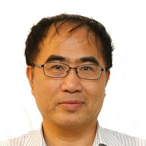 Portrait of a man with glasses and short dark hair wearing a striped shirt.