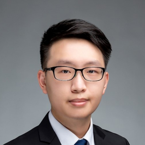 Professional headshot of a man wearing glasses and a suit.