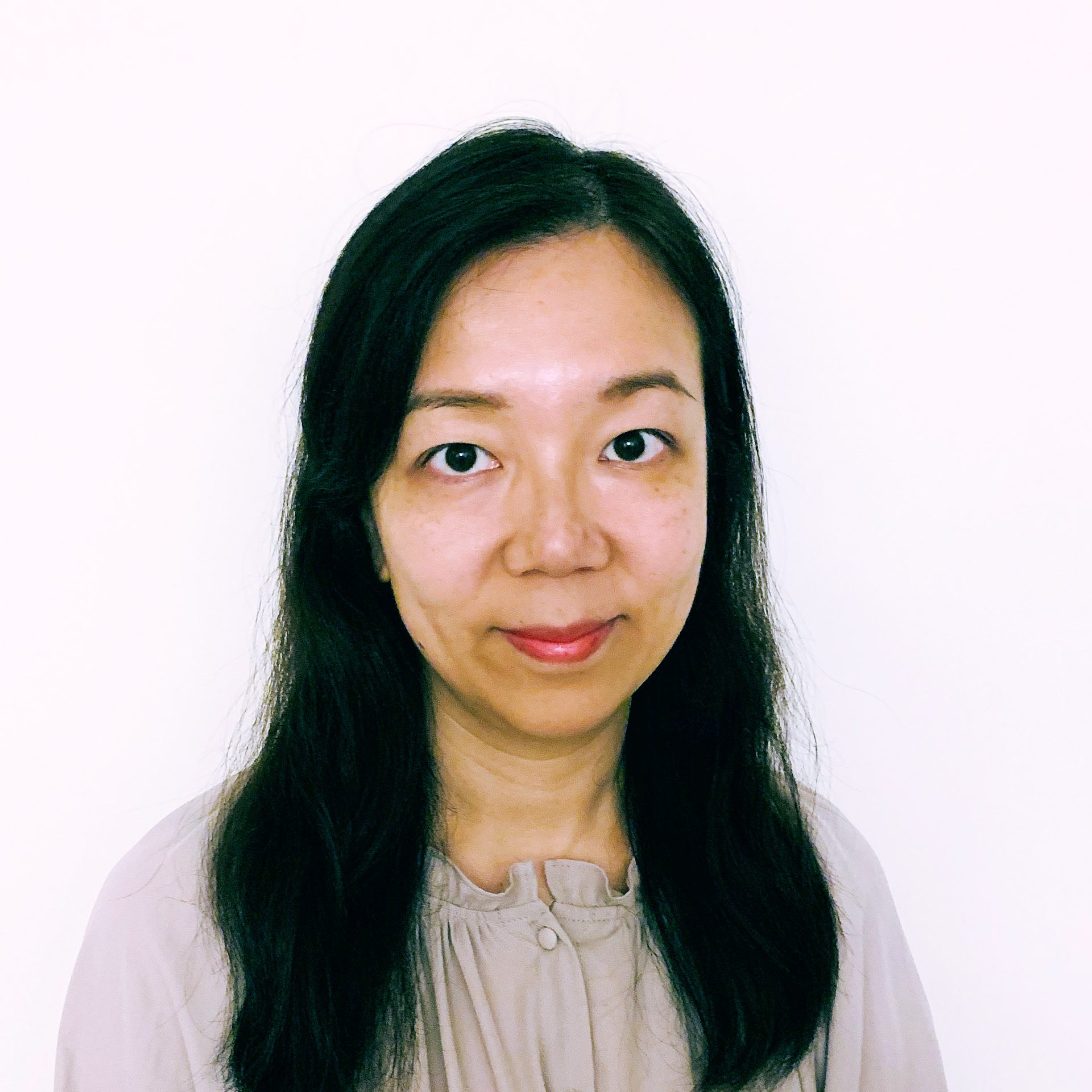 Portrait of a woman with long dark hair wearing a light-colored blouse.
