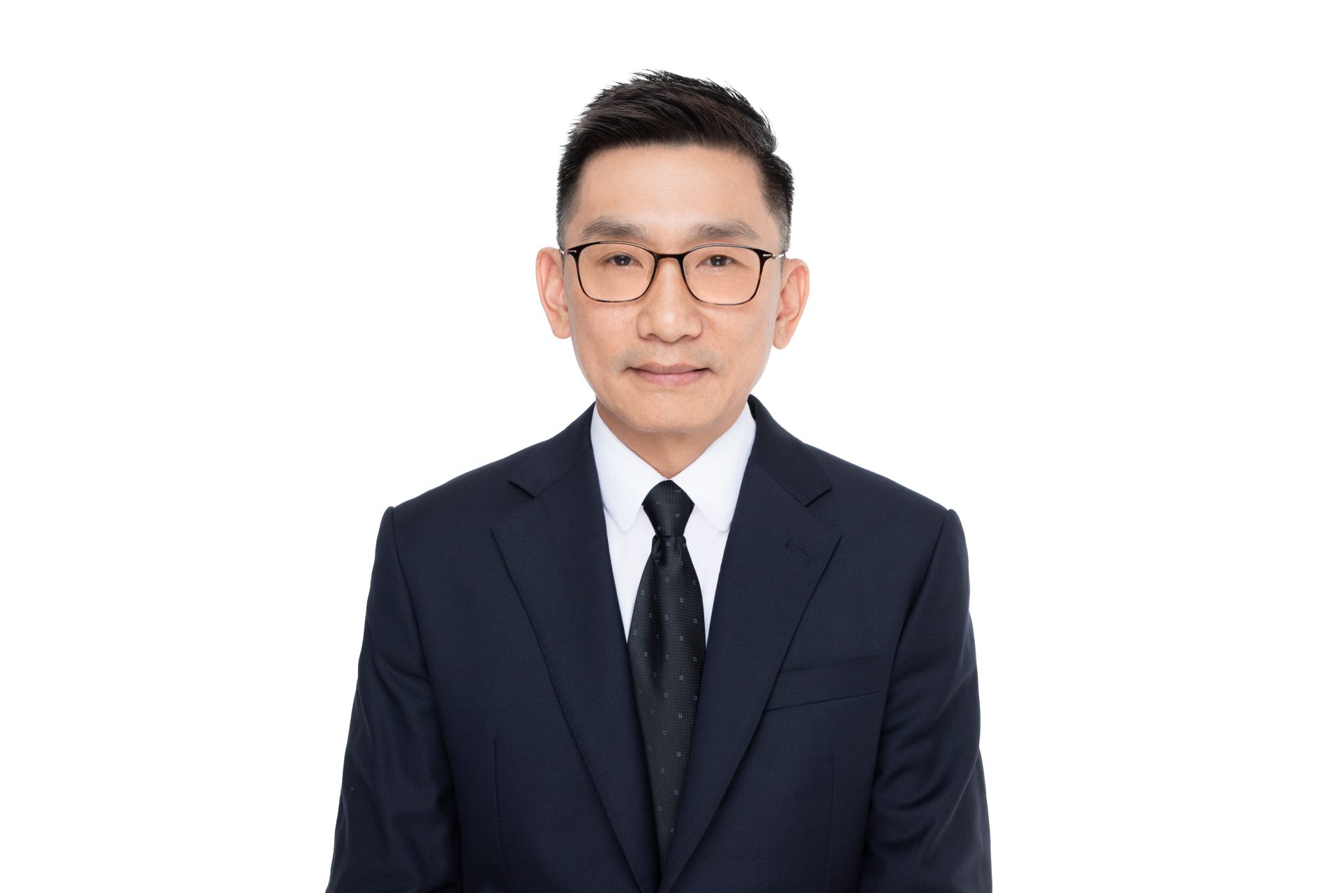 Man in dark suit and glasses against white background