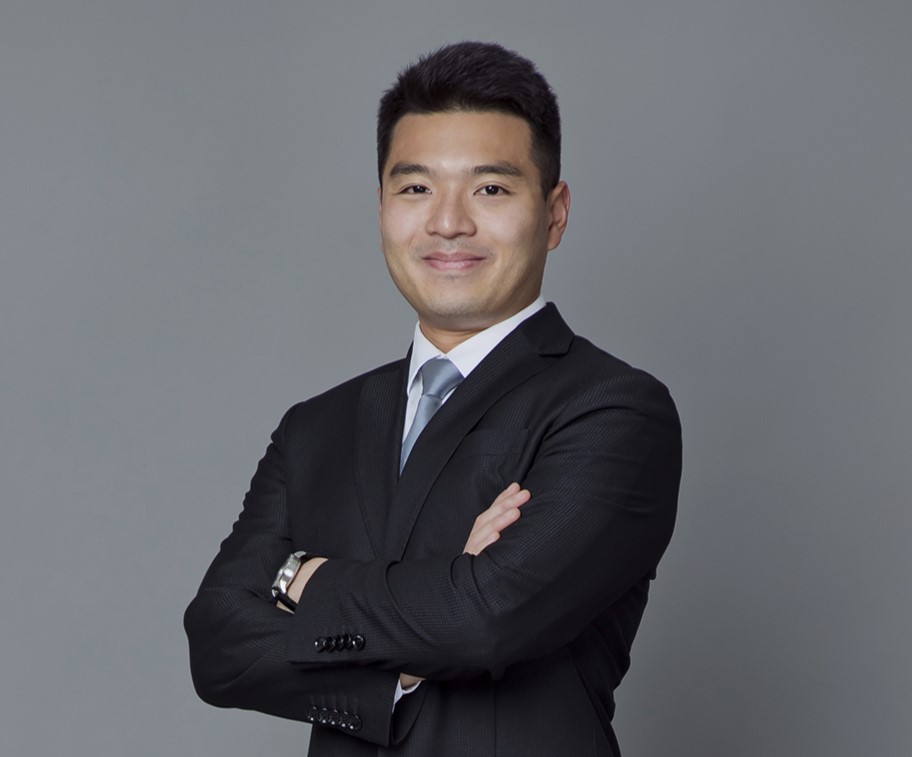 Professional man in suit with arms crossed, smiling at camera