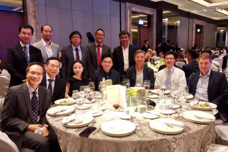 Group of professionals posing together at a formal dinner event.