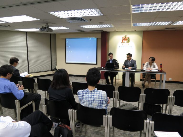 Panel discussion in conference room with attendees and speakers at table