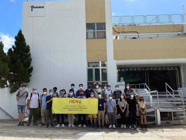 Group of people holding HKIE Geotechnical Division banner outside Fugro building.