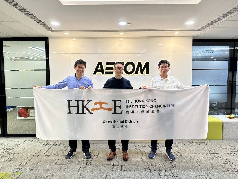 Three men holding a banner for The Hong Kong Institution of Engineers Geotechnical Division.