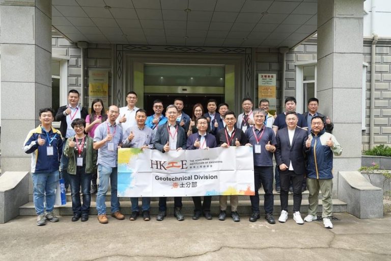 Group of engineers posing with banner for HKIE Geotechnical Division outside building
