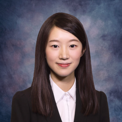 Professional headshot of a woman with dark hair wearing a blazer and collared shirt.
