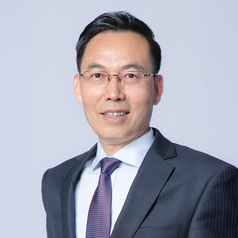 Professional headshot of a man in suit and glasses smiling