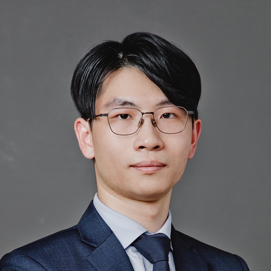 Portrait of a man with glasses wearing a suit and tie.
