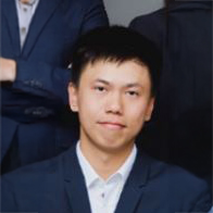 Man in business suit smiling with colleagues behind