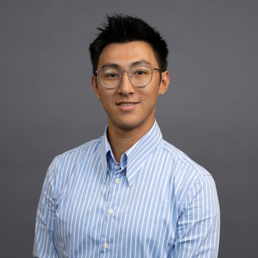 Portrait of a man with glasses wearing a blue and white striped shirt.