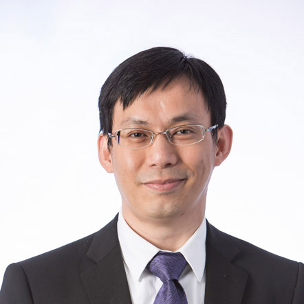 Portrait of a man with glasses wearing a suit and tie.