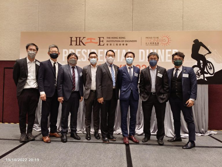 Group of eight men in suits and face masks posing at HKIE Presidential Dinner event.