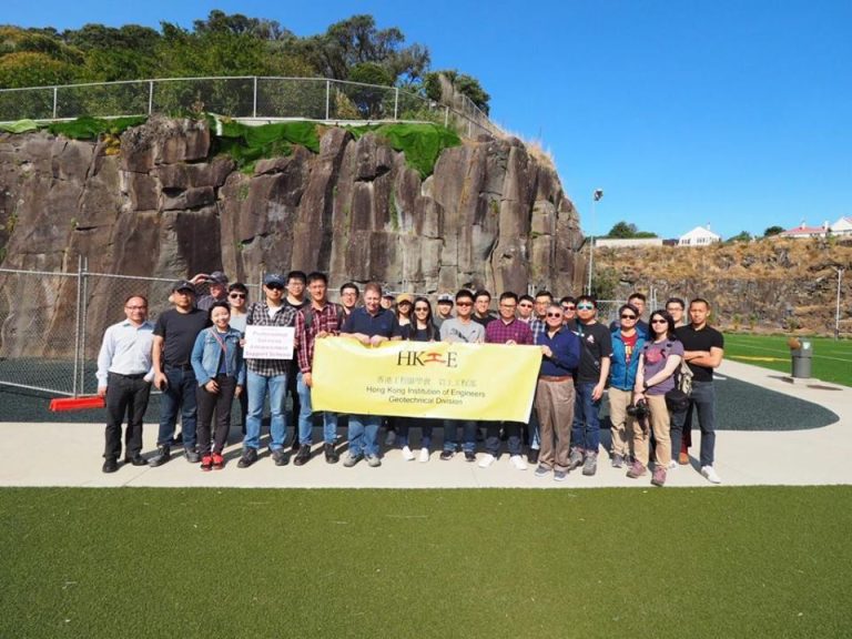 Group of people holding a banner for Hong Kong Institution of Engineers Geotechnical Division outdoors.