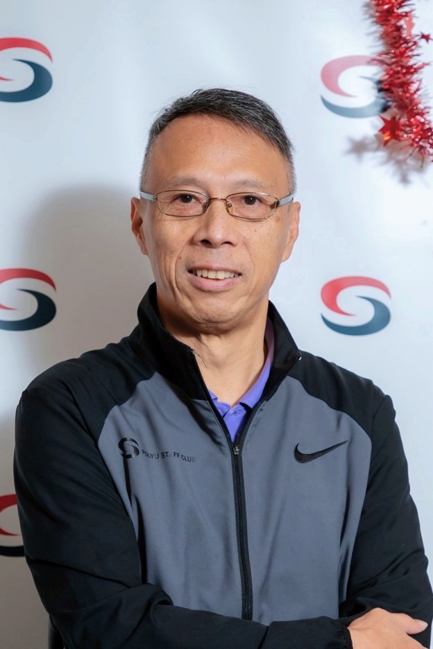 Man wearing glasses and a PolyU ST. FF Club jacket, smiling at camera.