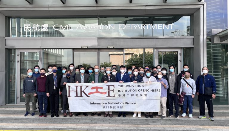 Group of engineers holding HKIE banner outside Civil Aviation Department building.