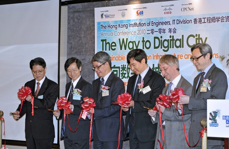 Five men in suits cutting a red ribbon at the 2010 Hong Kong Engineers IT Conference.