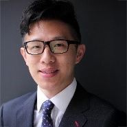 Portrait of a smiling man in glasses, suit, and tie, PSC 2024-2025 committee member