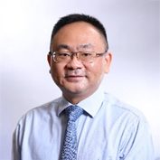 Dr. Howard Cheung Hoi Hoi, wearing glasses and a light blue shirt with patterned tie.