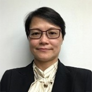 Portrait of a woman with glasses and dark hair wearing a blazer and bow tie.