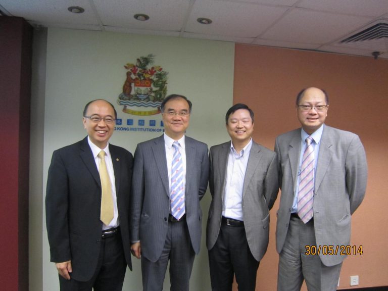 Four men in suits posing for a photo in front of Hong Kong Institution of Engineers logo.