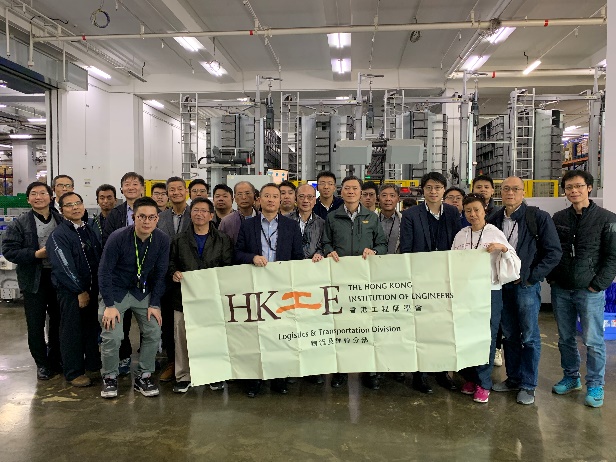 Group of people holding HKIE Logistics & Transportation Division banner in factory setting