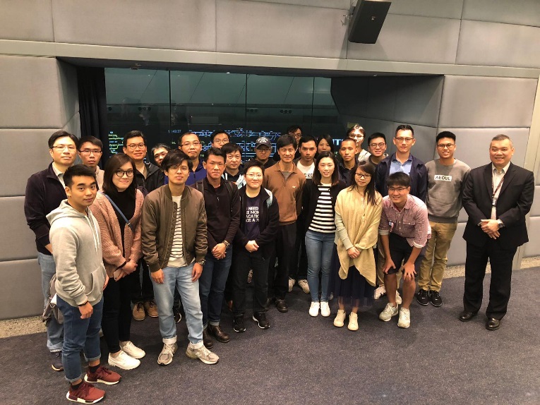 Group of people posing for a photo indoors, smiling and standing together.