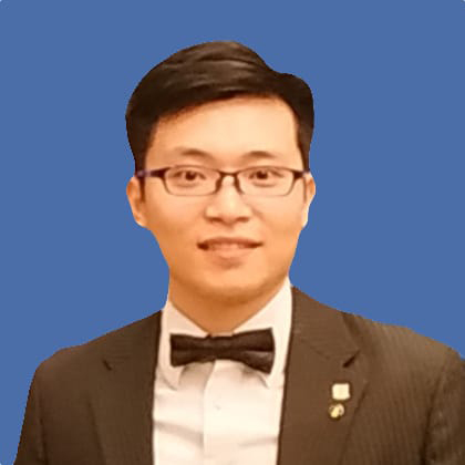 Man in suit and bow tie smiling against blue background