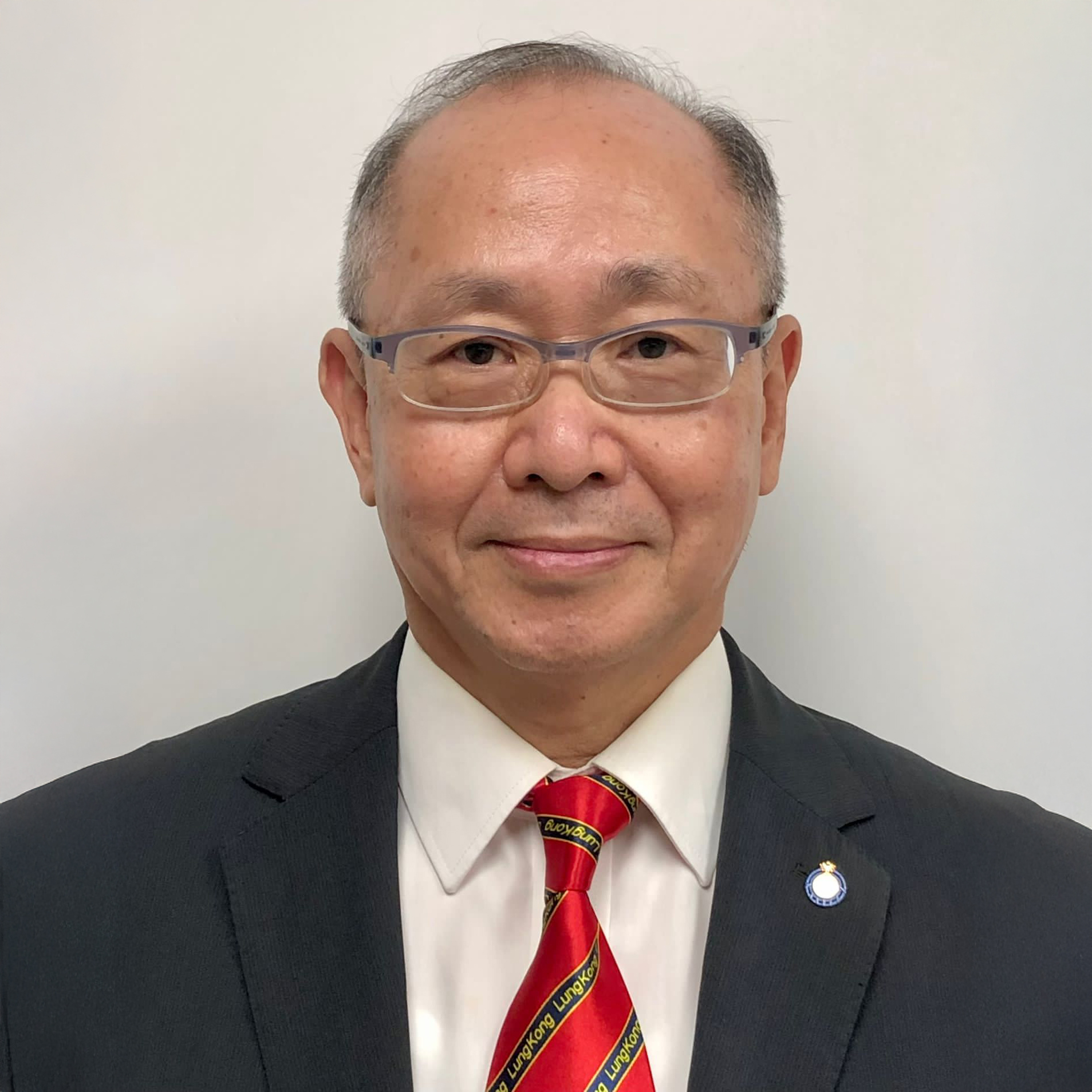 "Daniel Cheung, wearing glasses, dark suit, white shirt, and red tie with ""LungKong"" text."
