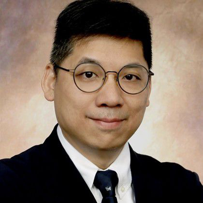Portrait of a man with glasses wearing a suit and tie.
