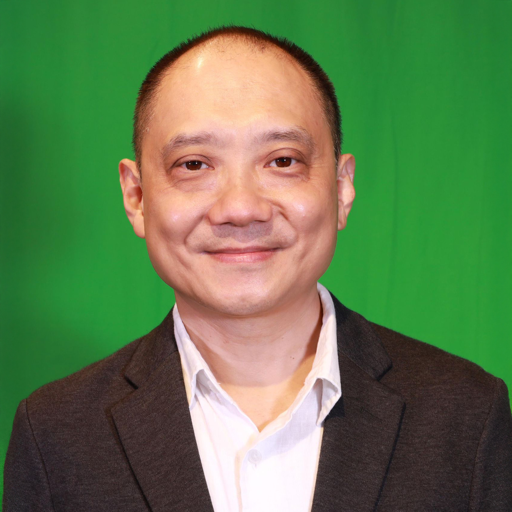 Portrait of Dr Timothy Lee smiling against green screen background.