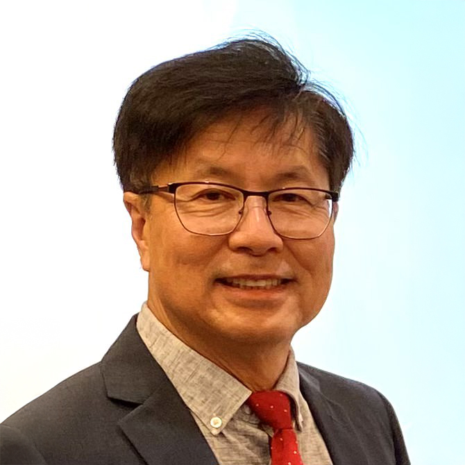 Man with glasses and red tie smiling in business attire