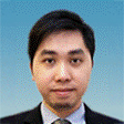 Portrait of a man in a suit and tie against a blue background.