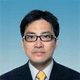 Man in suit and glasses with yellow tie against blue background