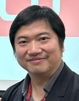 Portrait of a smiling East Asian man wearing a lanyard.