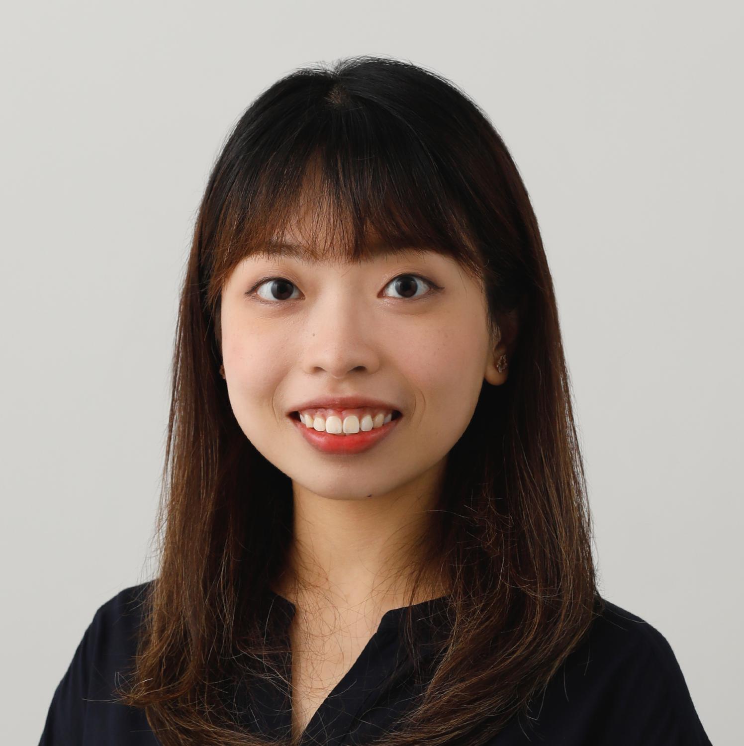 Portrait of Sheron, smiling with shoulder-length dark hair and red lipstick.
