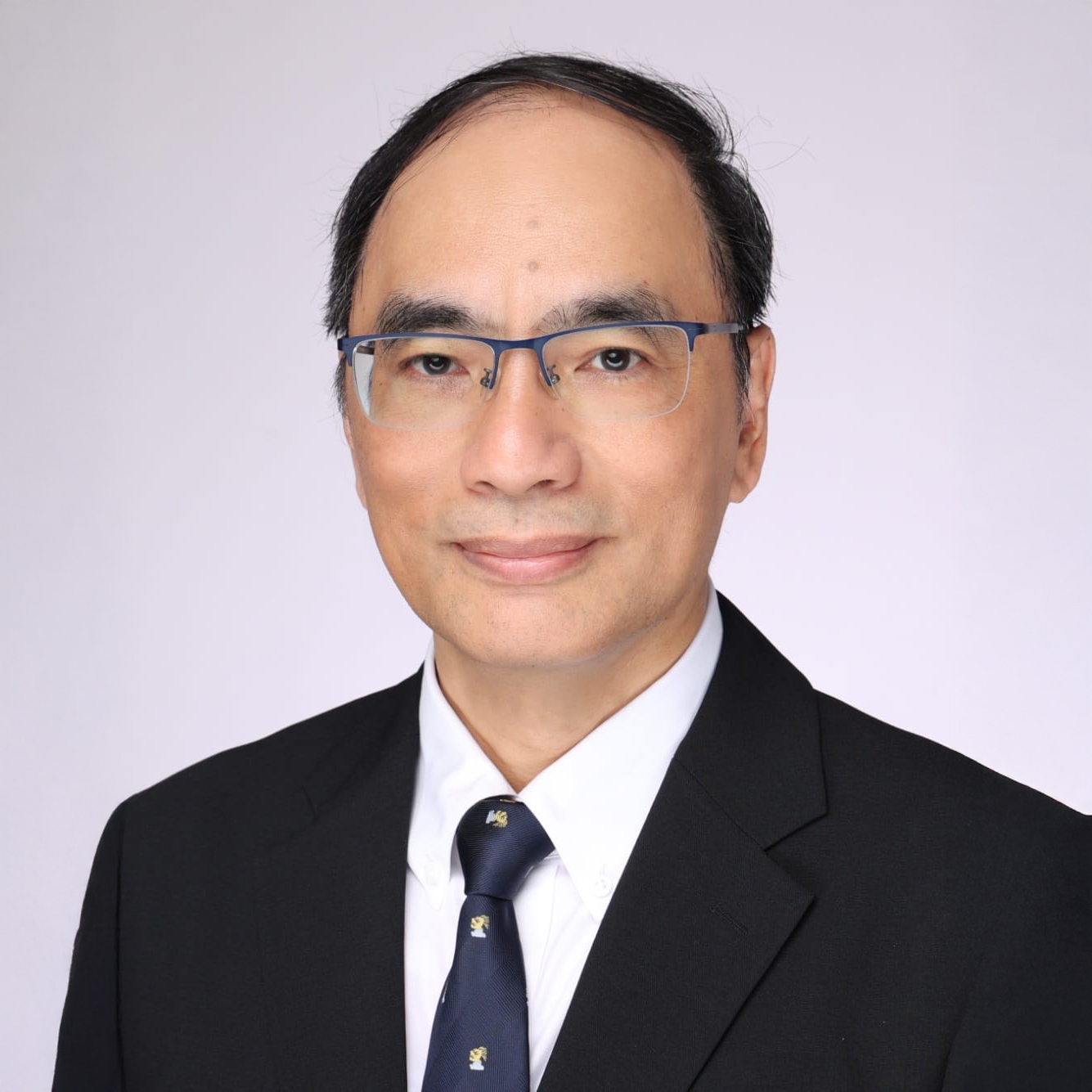 Portrait of Alfred HO Ka Lok wearing glasses, suit, and tie.