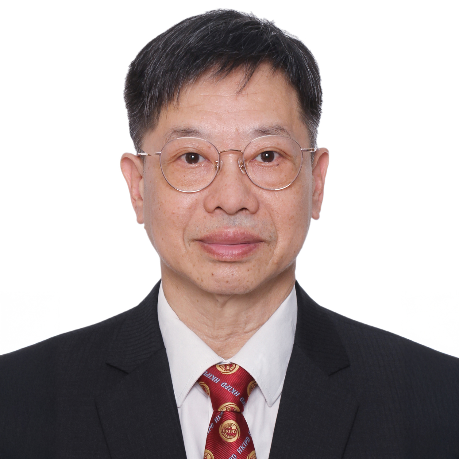 Man wearing glasses, dark suit, and red tie with HKIPD logo