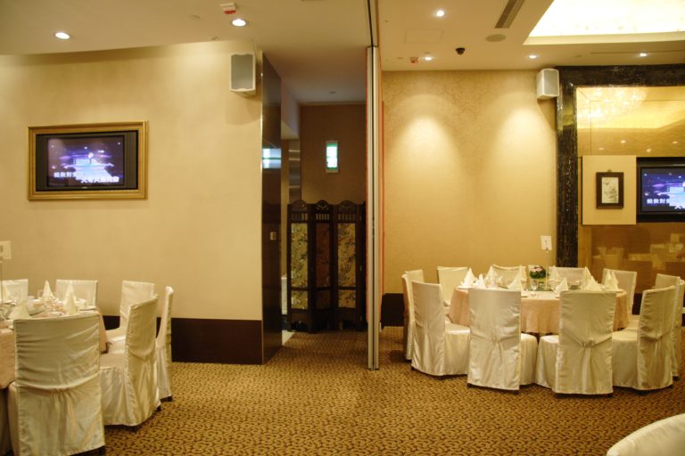Elegant restaurant dining area with set tables, chairs, and decorative screens.
