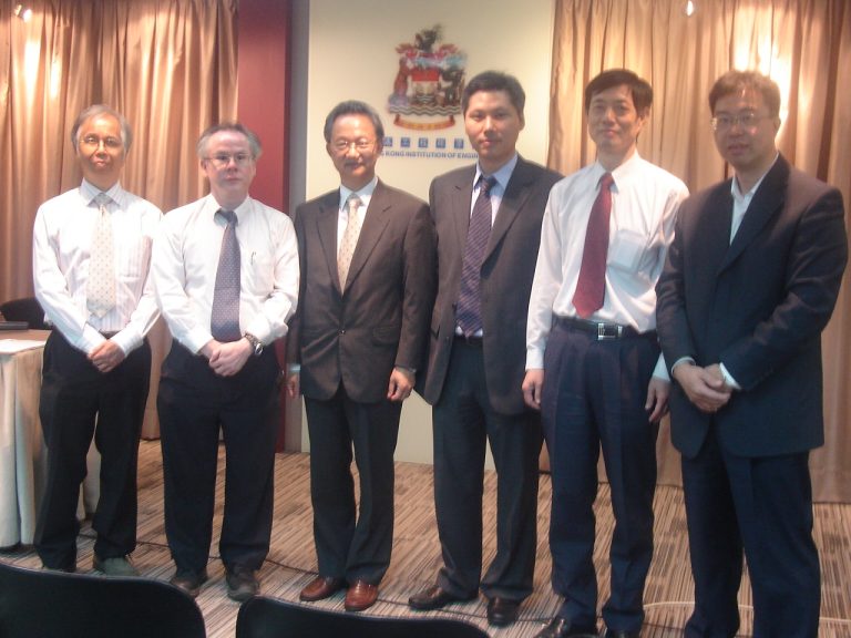 Six men in business attire standing for a group photo in front of a Hong Kong Institution of Engineers banner.