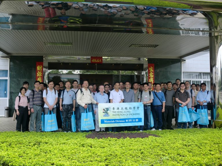 Group of engineers holding banner for Hong Kong Institution of Engineers Materials Division outside building.