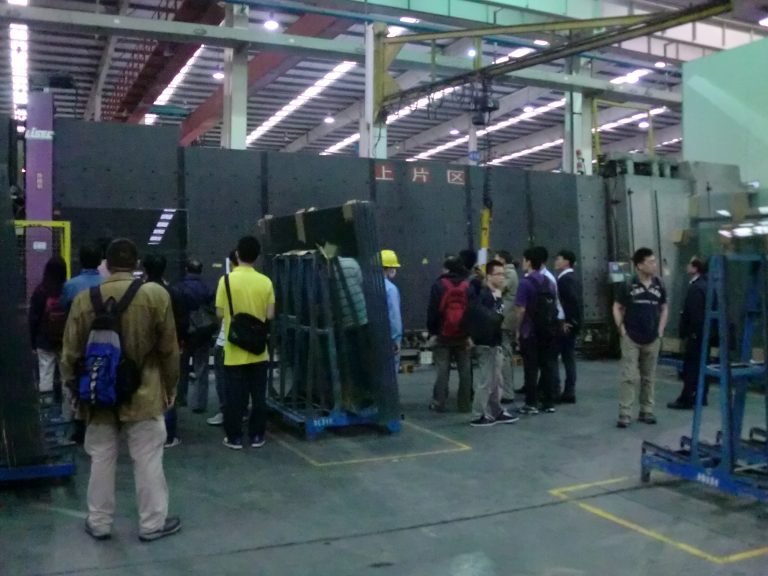 People touring a factory floor with machinery and equipment.