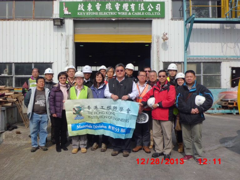 Group of engineers posing outside Key Stone Electric Wire & Cable Co., Ltd. holding HKIE Materials Division banner.