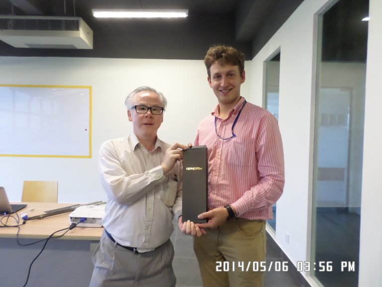 Two men holding a black award box in an office setting.