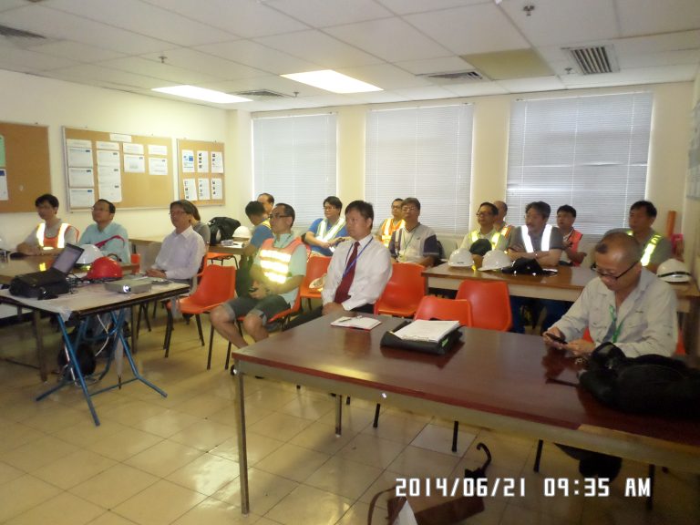 Group of construction workers in safety vests attending a training session in a classroom.