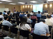 Audience seated in conference room watching presentation on screen