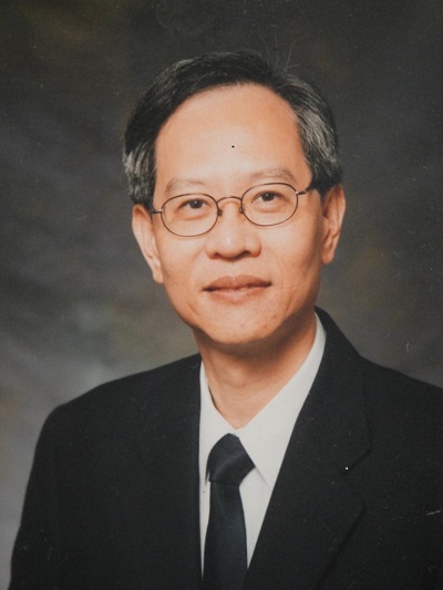 Portrait of a man with glasses wearing a suit and tie.